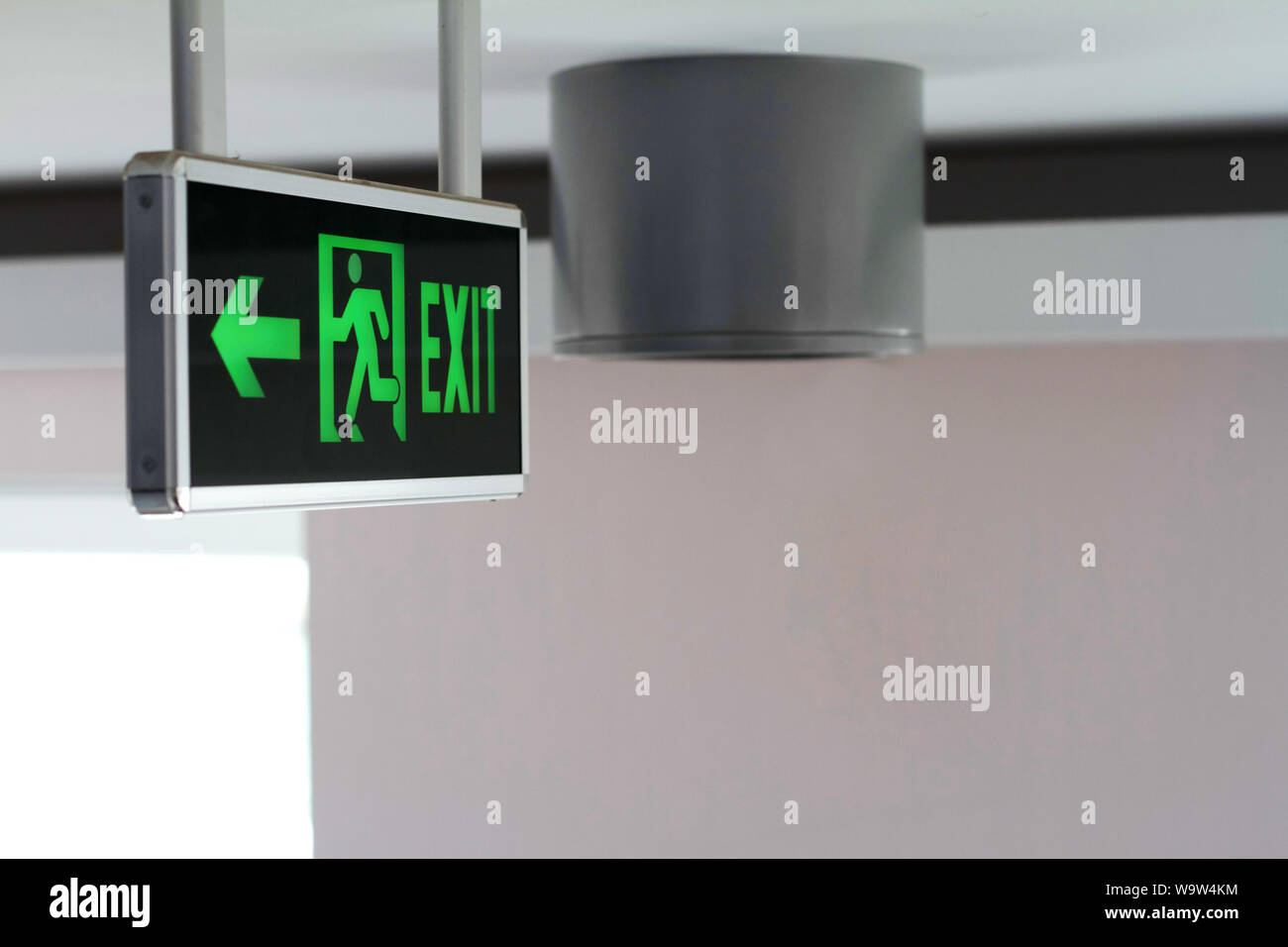 Side view of a green glowing sign with the words Exit and running man ...