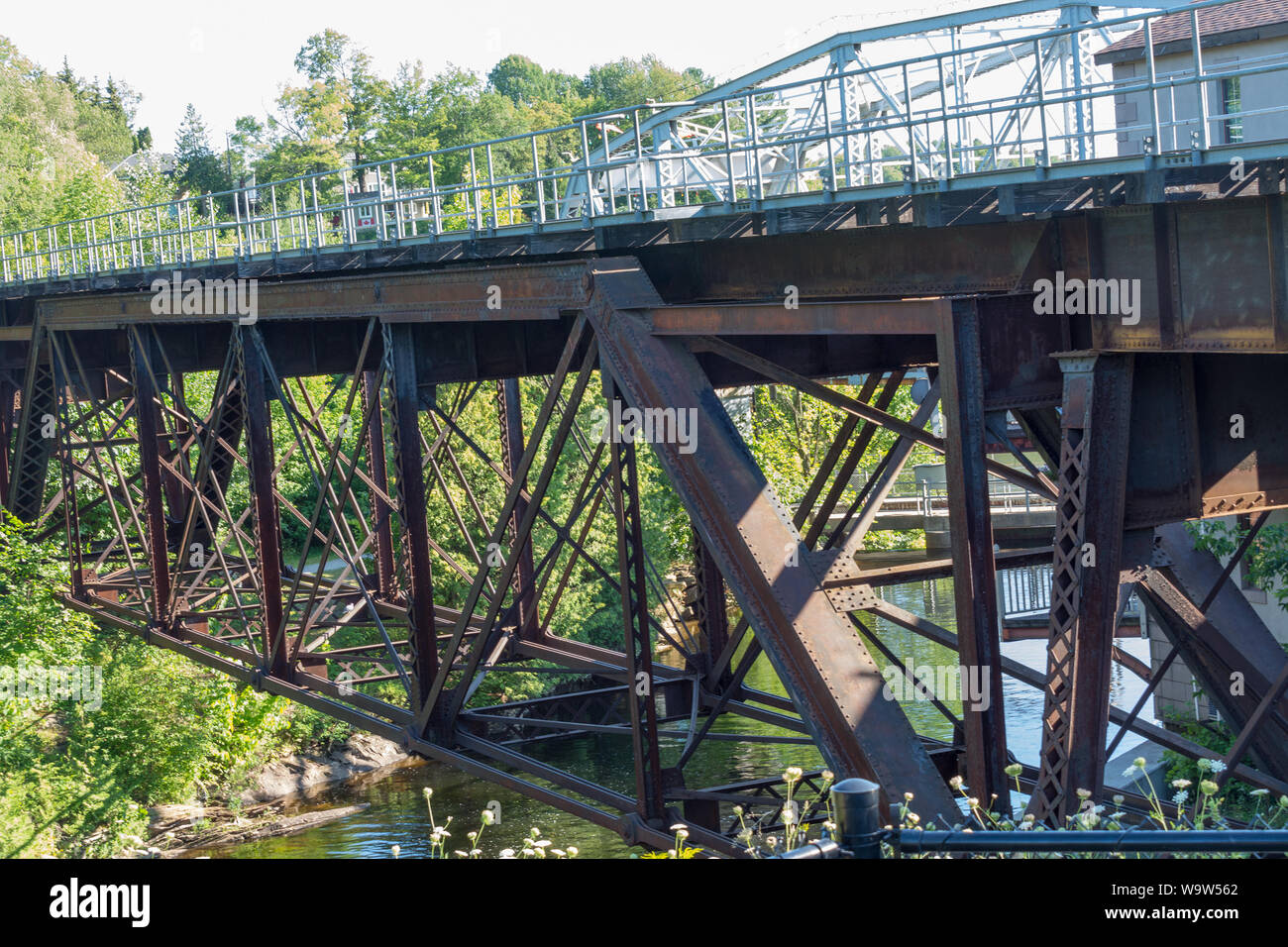 Railway bridge made of metal not protected from corrosion, but firmly standing on the river Stock Photo