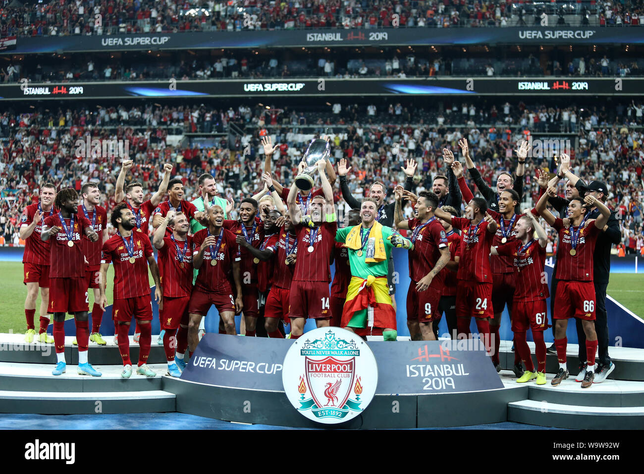 Jordan Henderson of Liverpool lifts the trophy with his team-mates at the  end of the