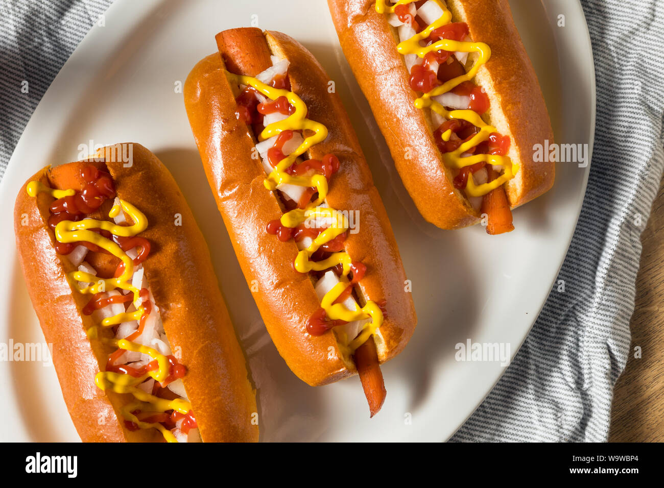 Homemade Vegan Carrot Hot Dogs with Onion and Mustard Stock Photo