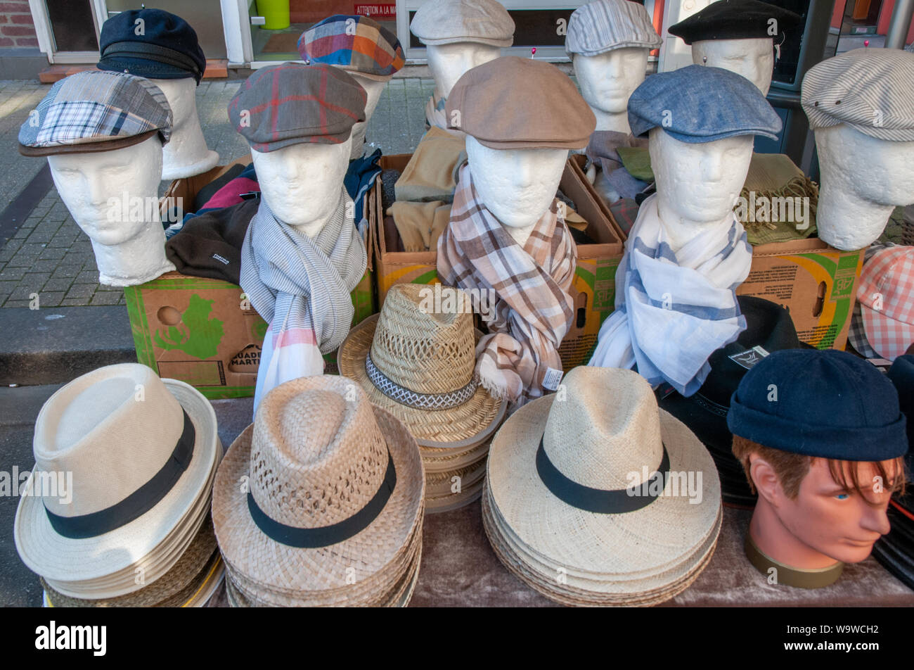A display of hats and caps at a market stall in open air market in centre of Dieppe, France Stock Photo