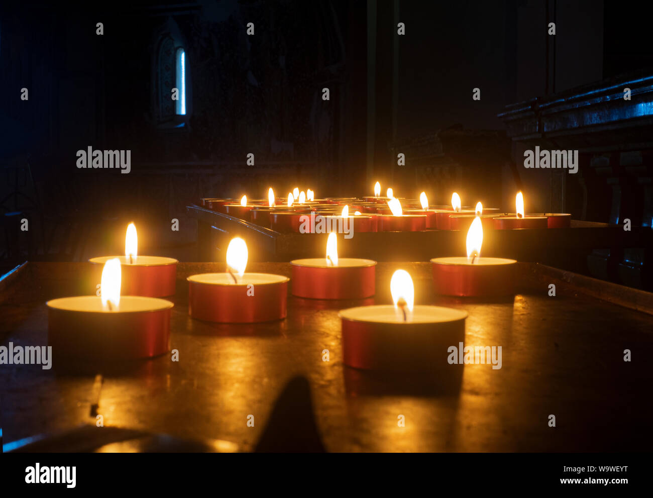 the candle flames lighten the darkness Stock Photo Alamy