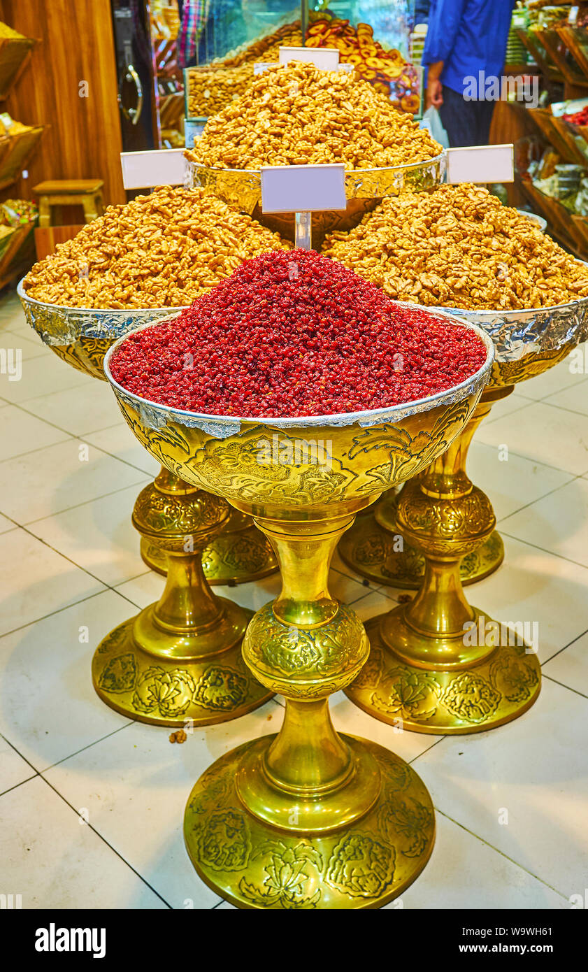 The beautiful brass vases, filled with walnuts and dried barberries in stall of Tajrish Bazaar, Tehran, Iran Stock Photo
