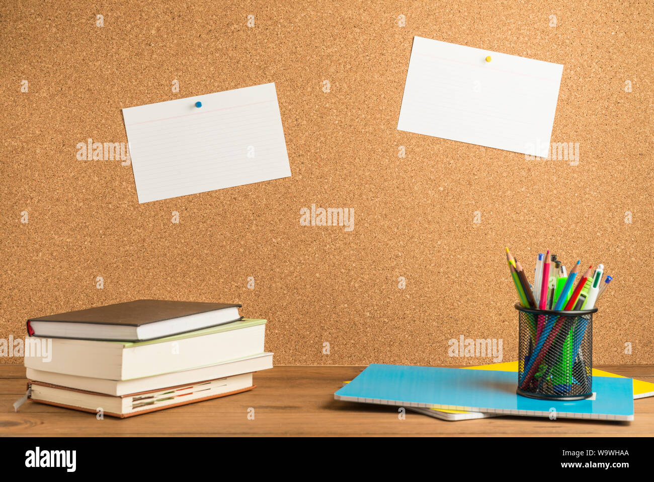 Books, notebooks and a pencil holder with pencils, pens and various