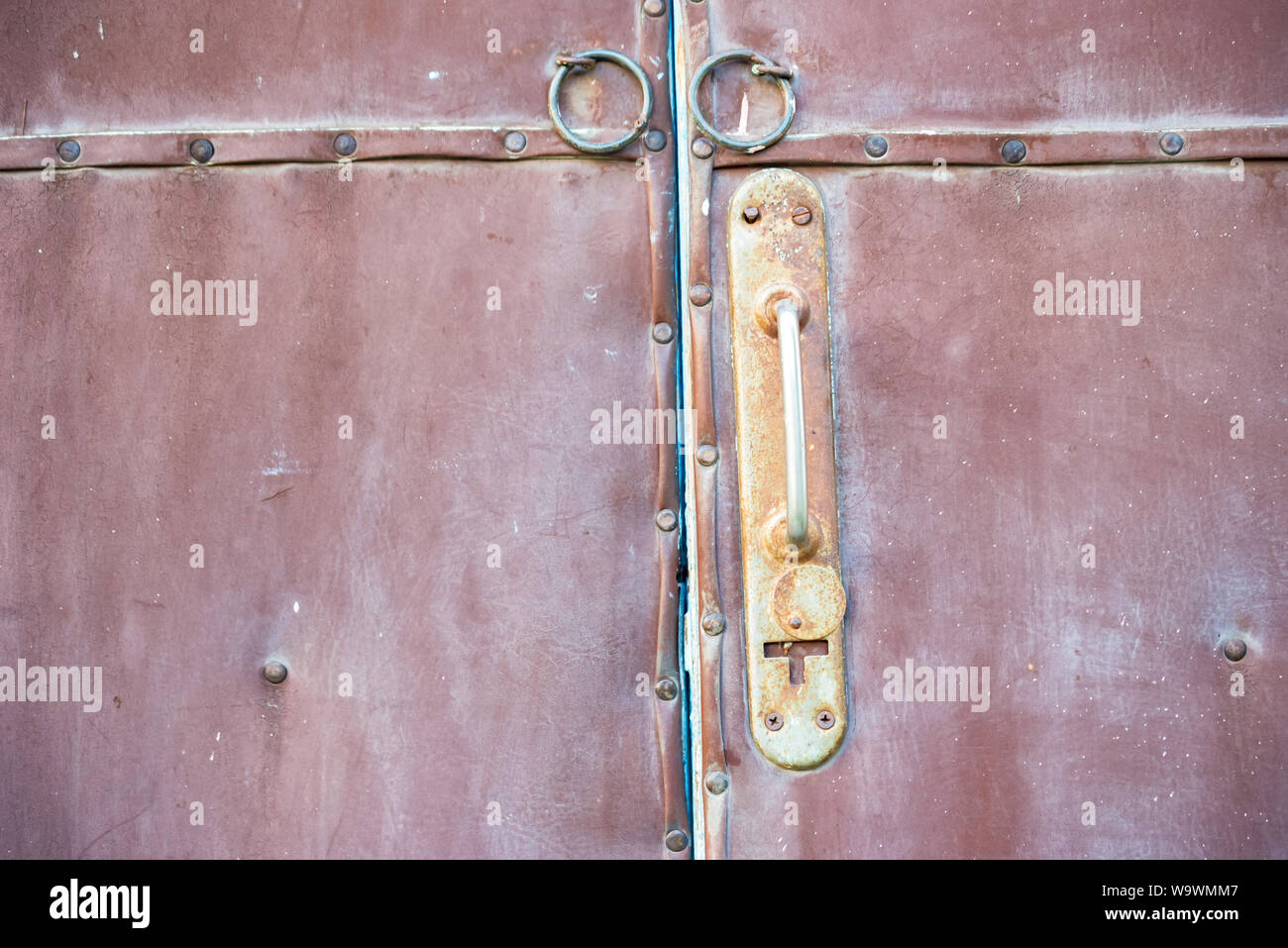 Close up old red door and rusty door handle Stock Photo