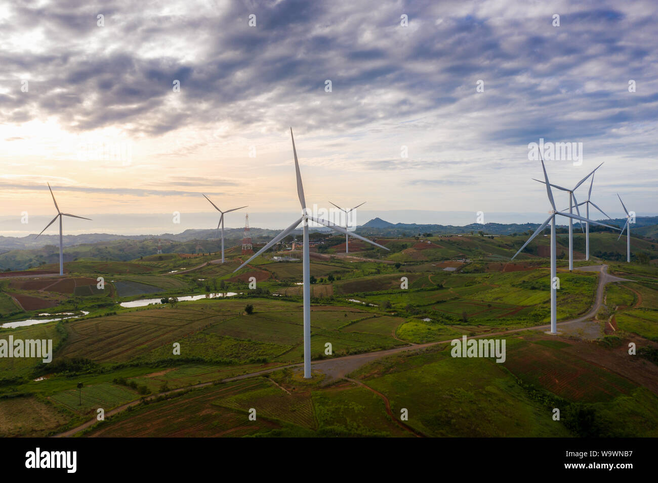 Wind turbines and agricultural fields on a summer day - Energy Production with clean and Renewable Energy - aerial shot Stock Photo