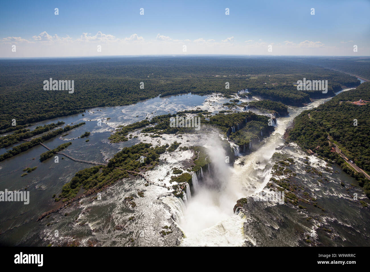 Aerial view of forest and waterfalls in Iguazu river in sunny summer day. Foz de iguaçu divides the border between Brazil and Argentina and is One of Stock Photo