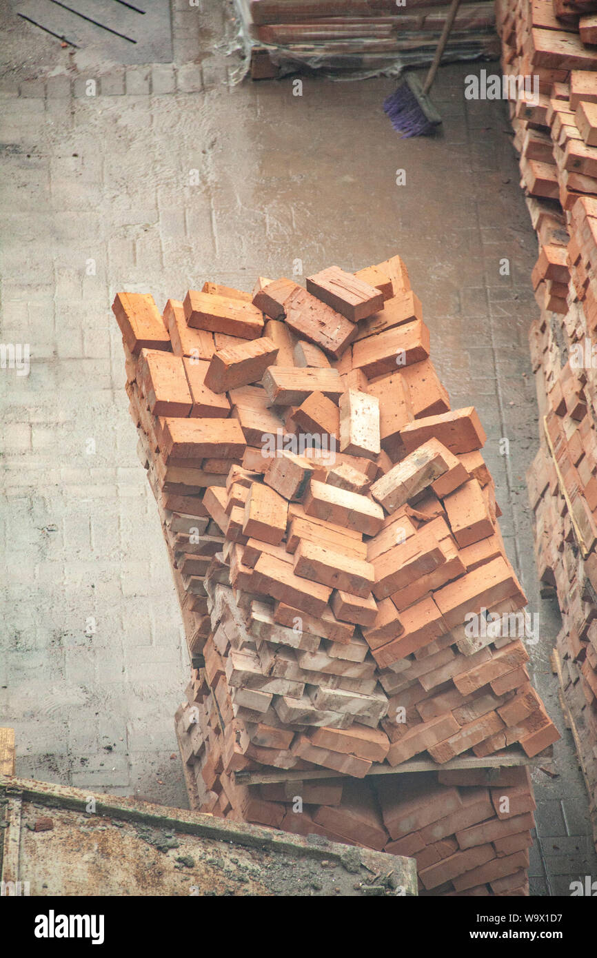 Stack of orange clay brick on construction site Stock Photo - Alamy