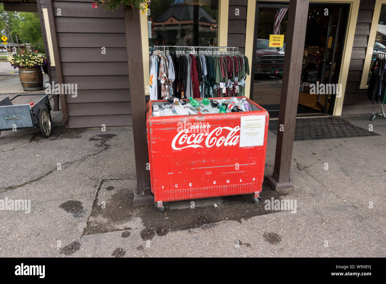 Red, vintage Coca Cola outside ice cooler / fridge holding sodas at the front of the store Stock Photo