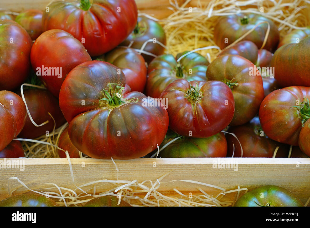 Crate of colorful organic heirloom tomatoes at the farmers market Stock ...