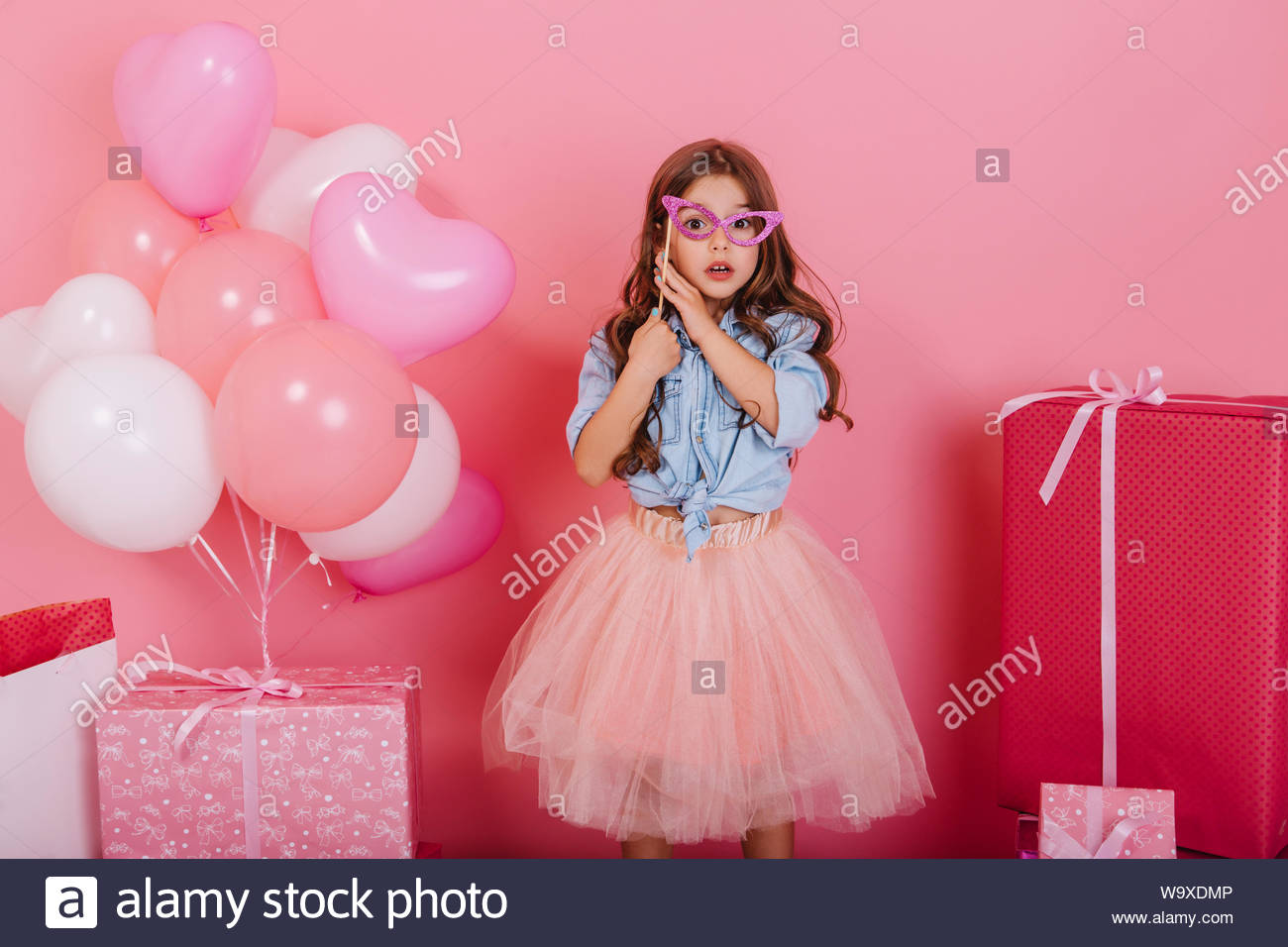 Cute Surprised Little Girl With Long Brunette Hair Holding Mask On