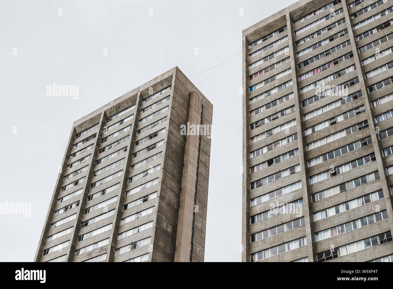 Dull looming towers of public housing flats against a cloudy sky Stock Photo