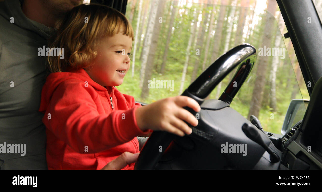 Happy little kid driving car with father Stock Photo