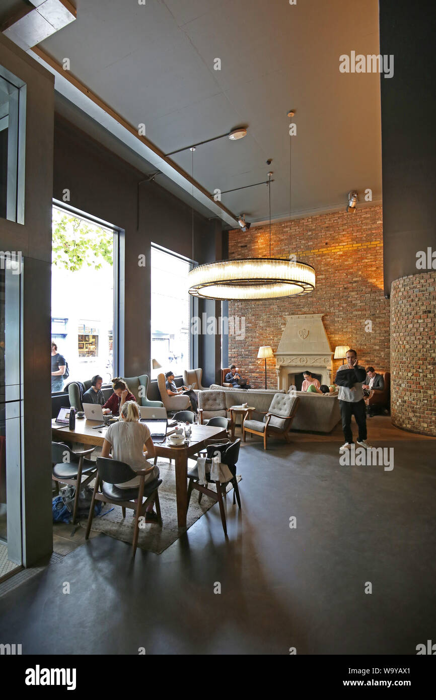 Customers relax in the entrance lobby, bar and restaurant area at London's trendy Hoxton Hotel in Shoreditch, UK Stock Photo