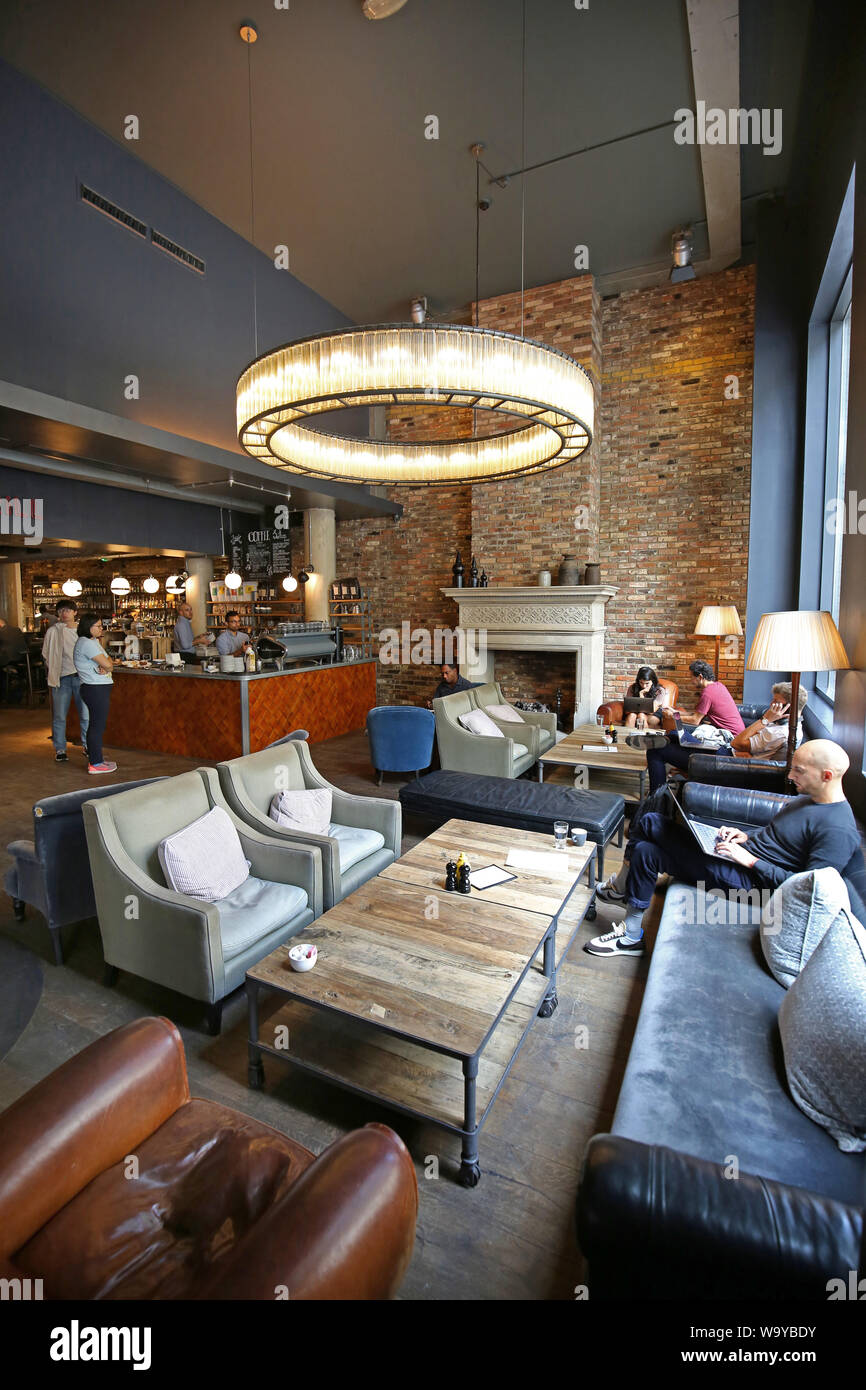 Customers relax in the entrance lobby, bar and restaurant area at London's trendy Hoxton Hotel in Shoreditch, UK Stock Photo