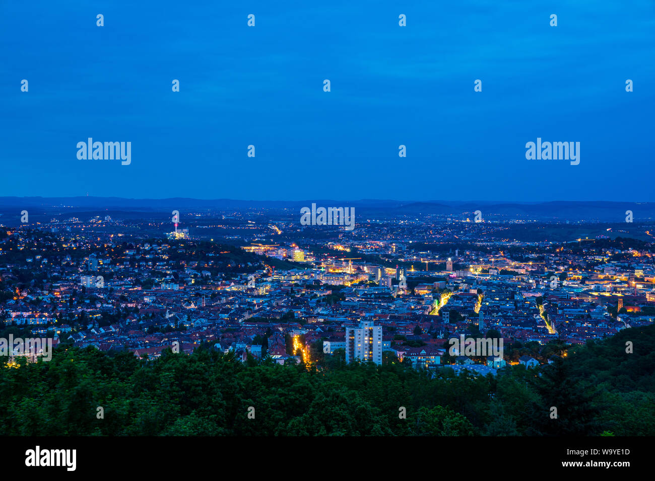 Germany, City centre of stuttgart metropolis from above by night in beautiful green hilly nature landscape from peak of birkenkopf mountain Stock Photo