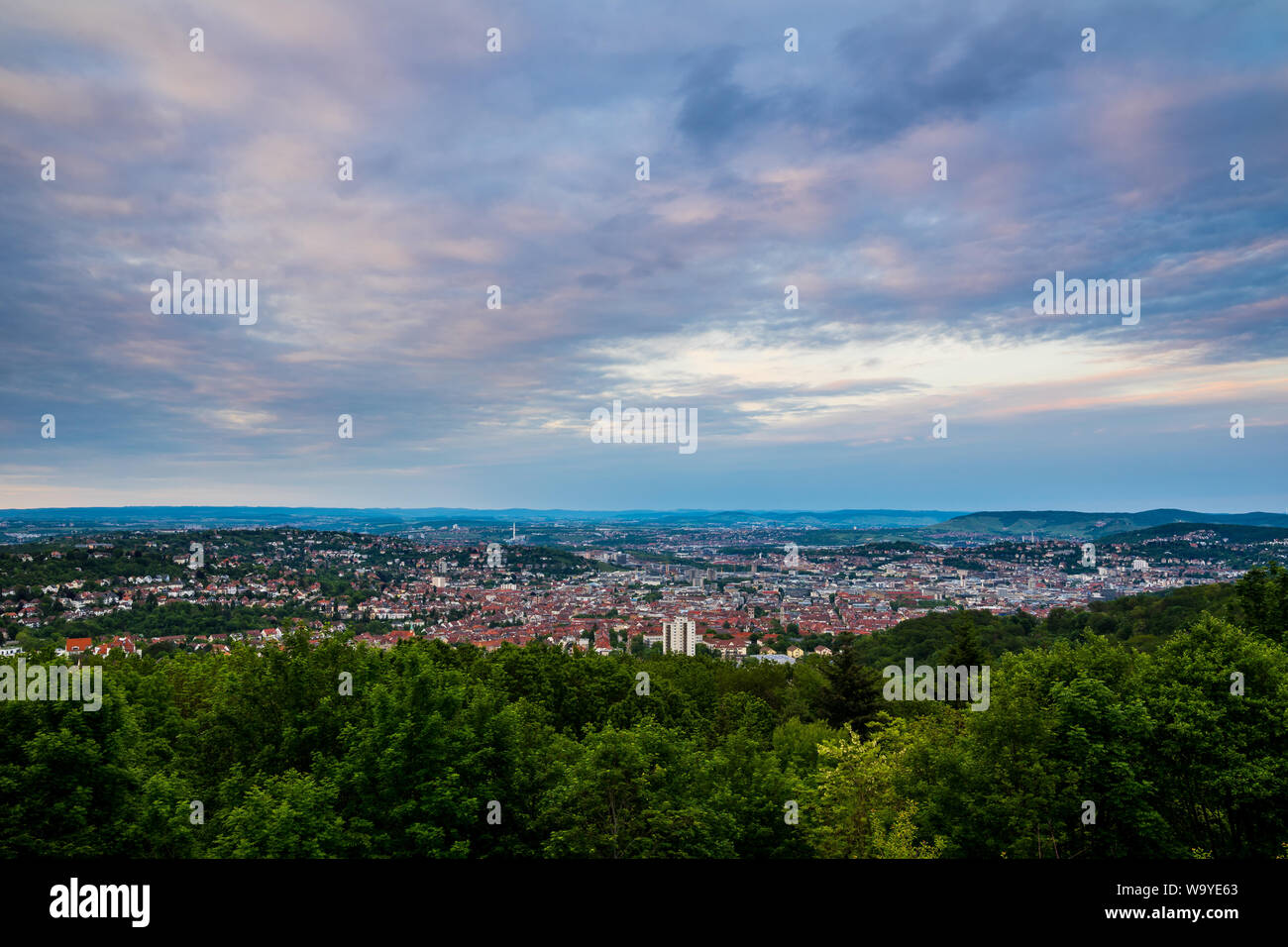 Germany, Stuttgart city metropolis of countless houses and buildings forming skyline in valley from mountain rubble at sunset Stock Photo