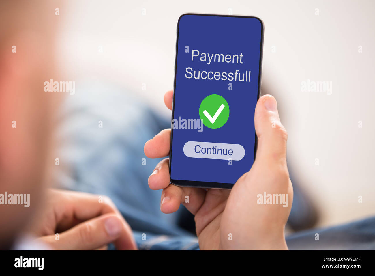 Close-up Of Person's Hand Showing Payment Successful Message On Mobilephone Screen Stock Photo