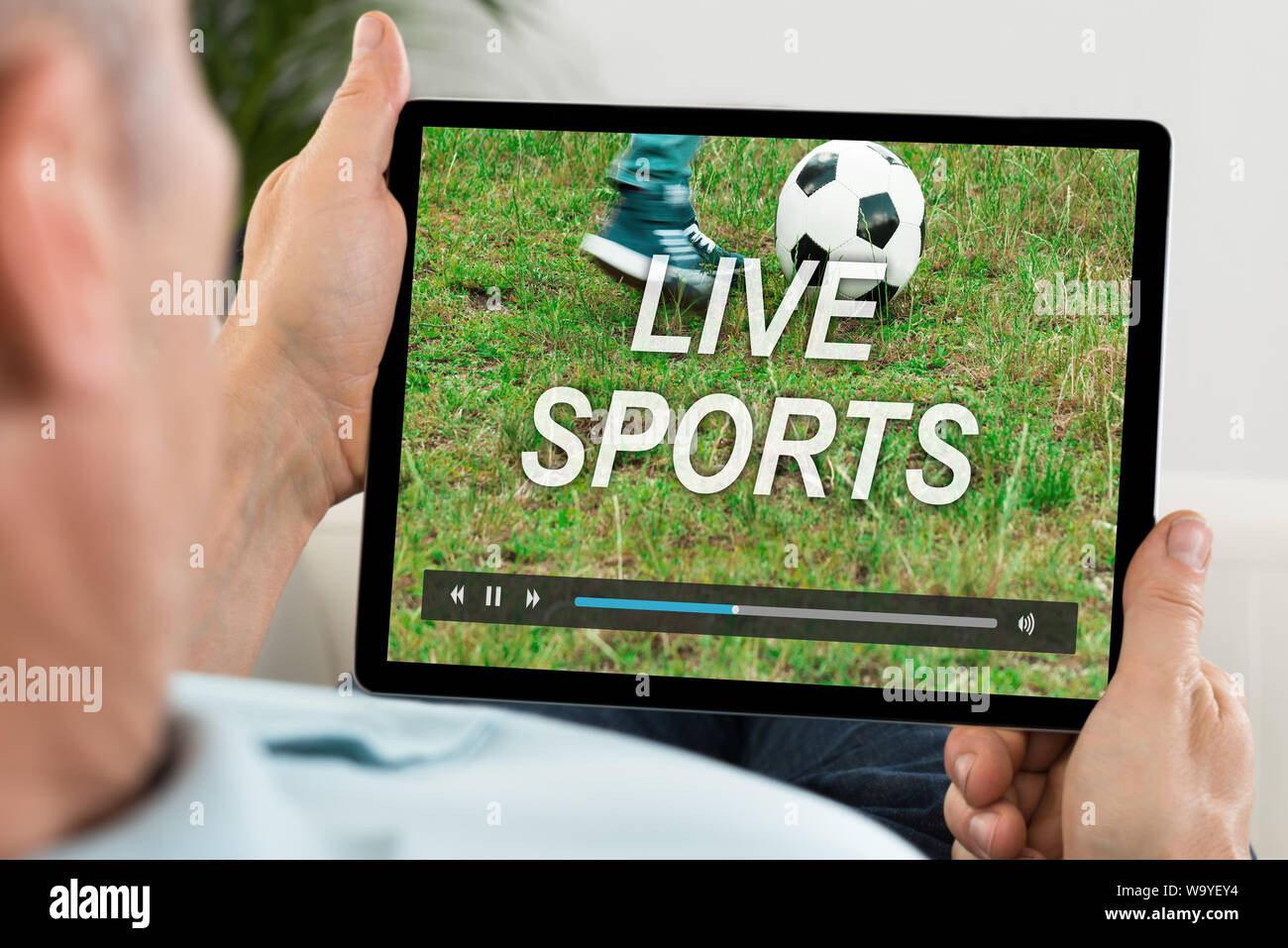 Man Watching Live Football Match On Digital Tablet Stock Photo