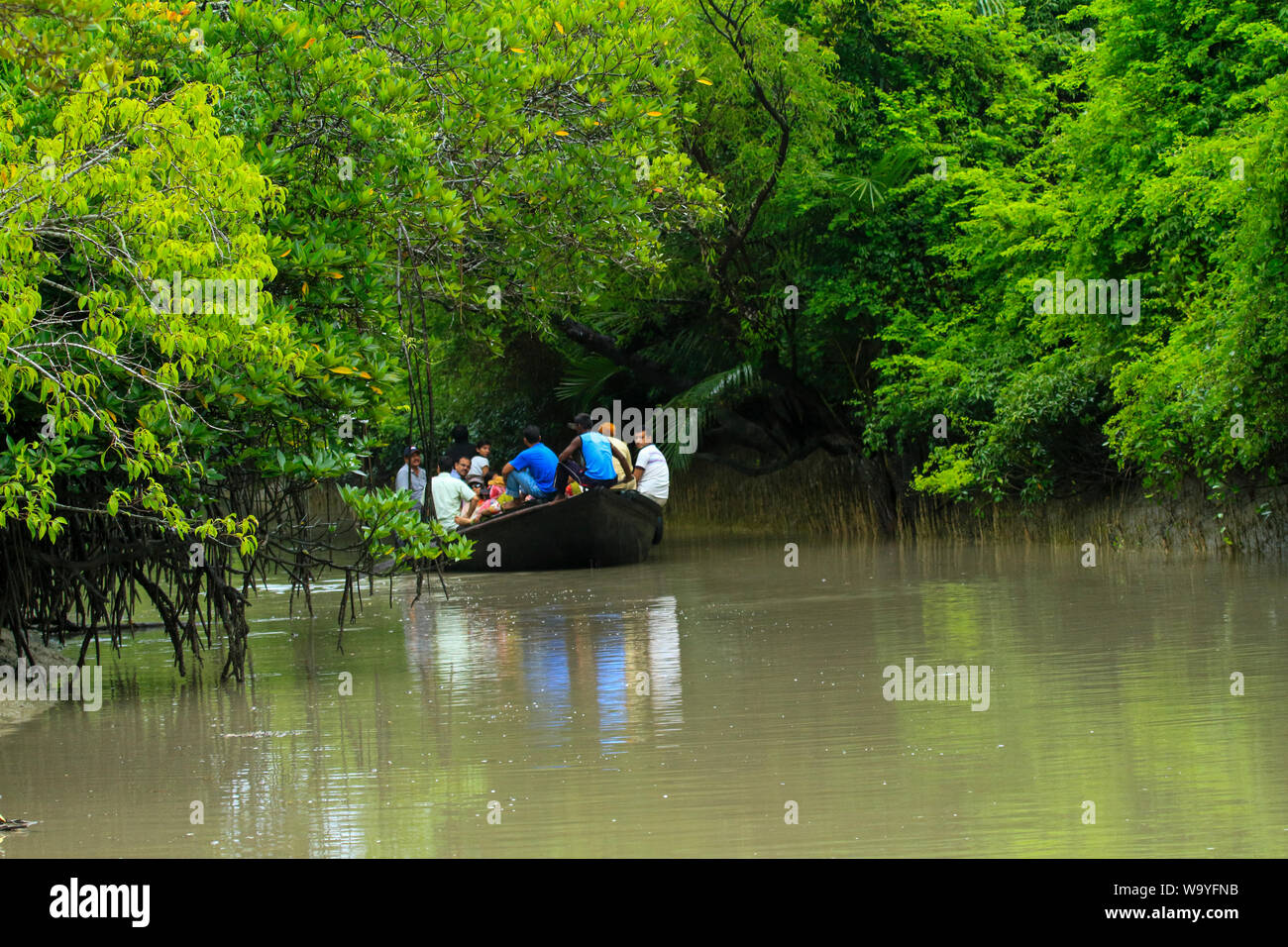 Tourists roam on a boat inside the Sundarbans, the largest mangrove forest in the world. Bangladesh. Stock Photo