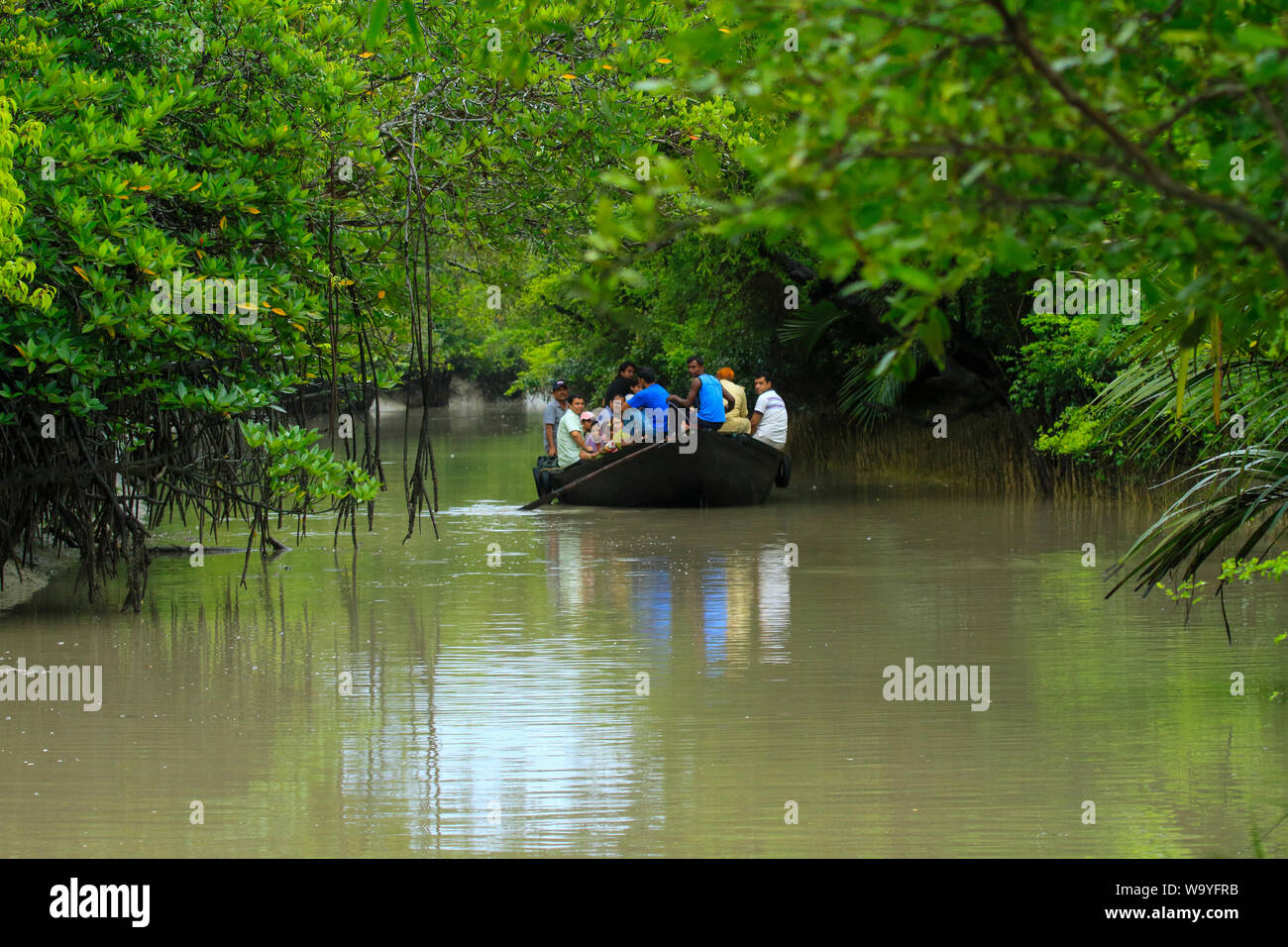 Tourists roam on a boat inside the Sundarbans, the largest mangrove forest in the world. Bangladesh. Stock Photo