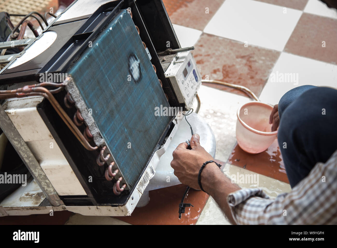 Worker cleaning window air conditioner by water for clean a dust