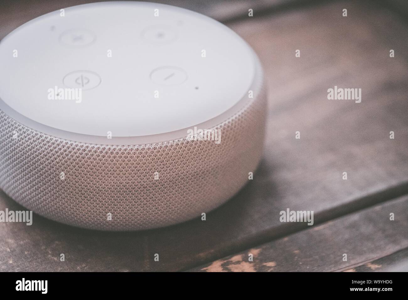 Closeup shot of a round wireless Bluetooth speaker on a wooden surface Stock Photo