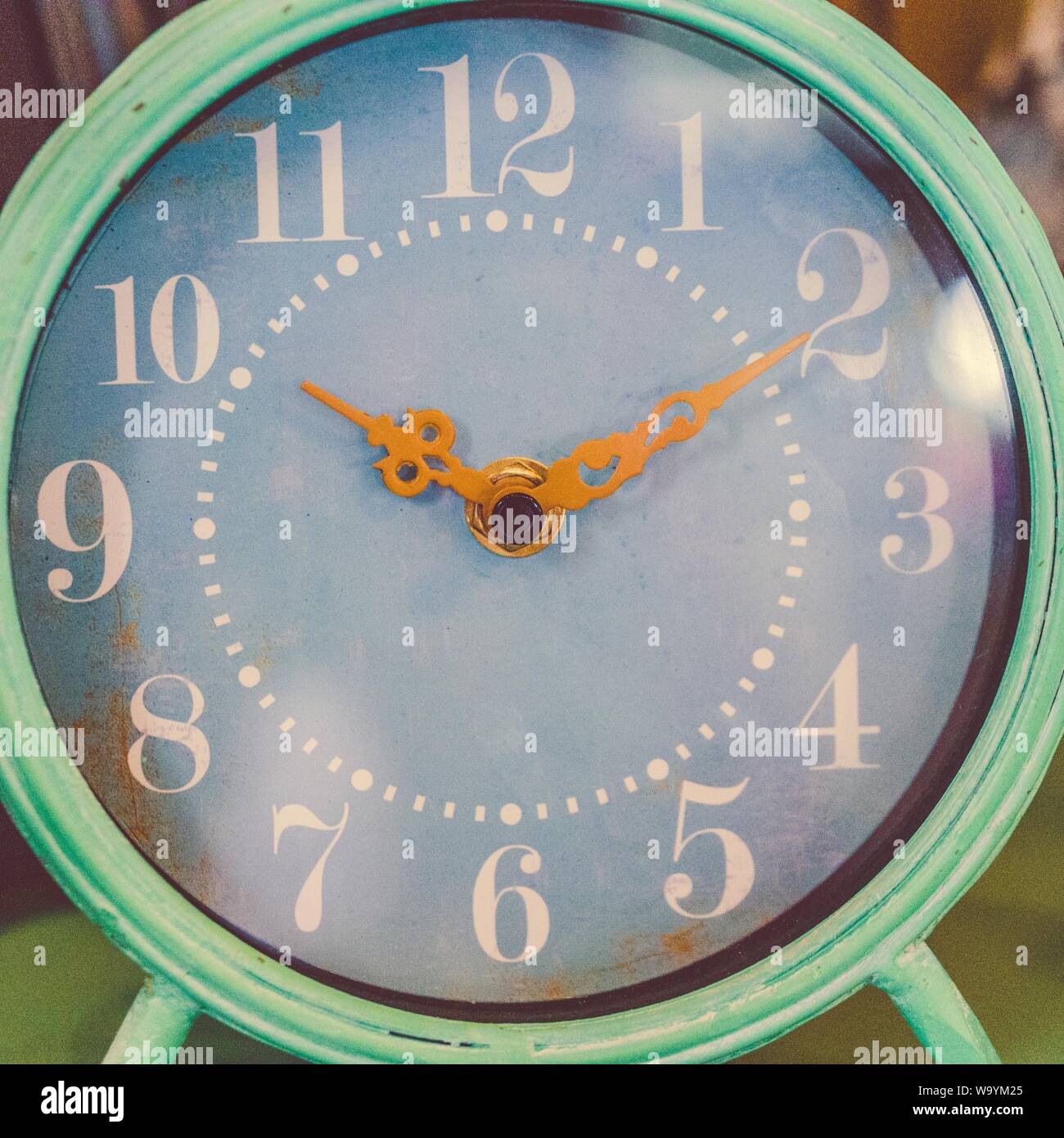 Round teal and white analog table clock displaying 1010 time Stock