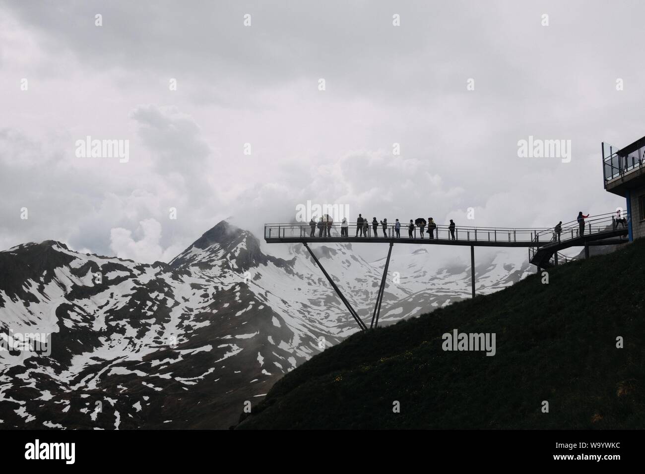 A Wide Low Angle Shot Of People On A Dock Near Mountains Covered