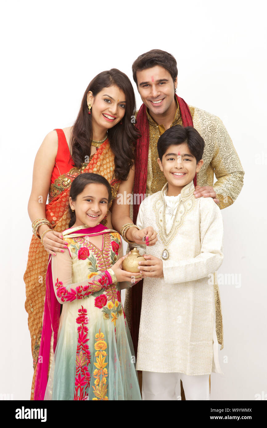 Family putting coin into a piggy bank Stock Photo - Alamy