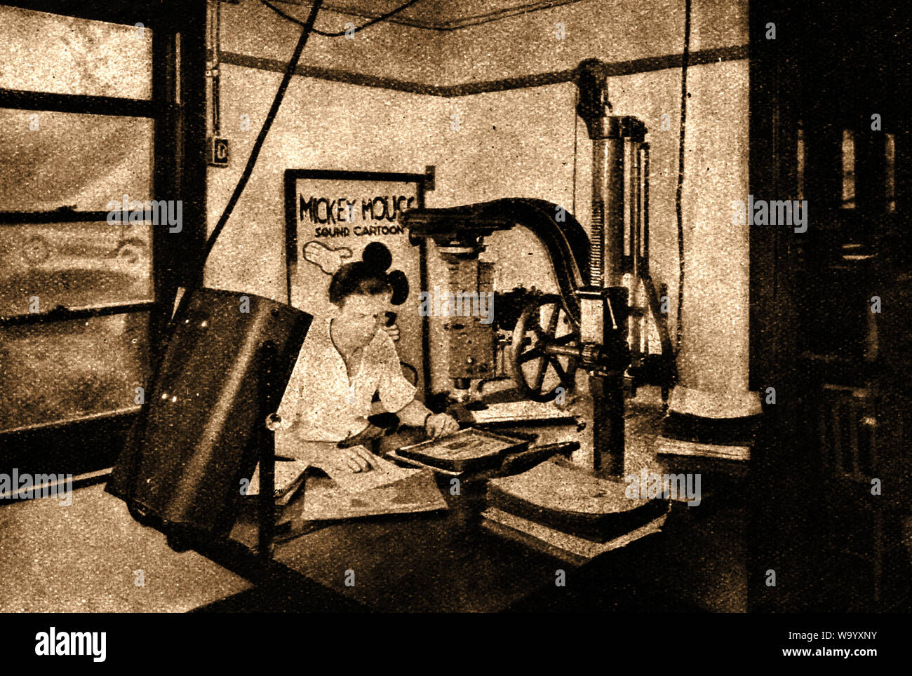 An early photograph of the Disney film Studios where a technician is using cel animation making a sound cartoon film of Mickey Mouse using the old method of individual frames Stock Photo