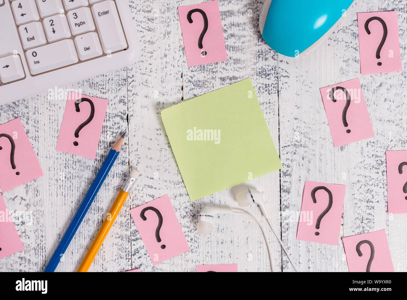 Writing tools, computer stuff and scribbled paper on top of wooden ...