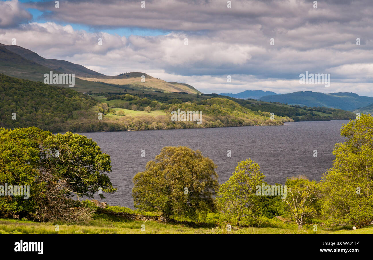 Woodland-covered mountains rise from the shores of Loch Tay in the Perthshire Highlands of Scotland. Stock Photo