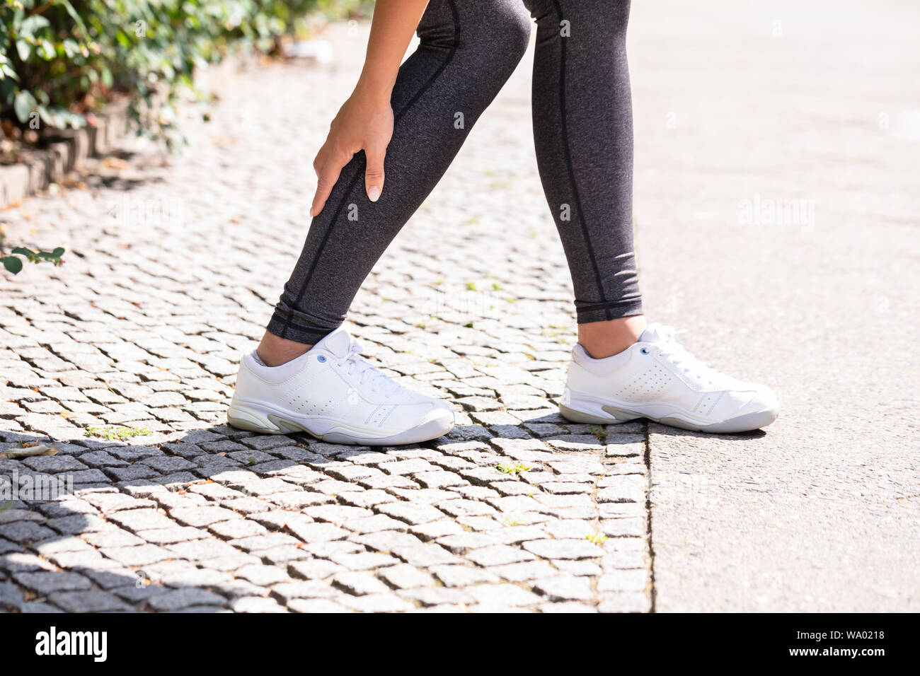 Close-up Of A Female Runner Suffering From Pain In Calf Muscle Stock Photo