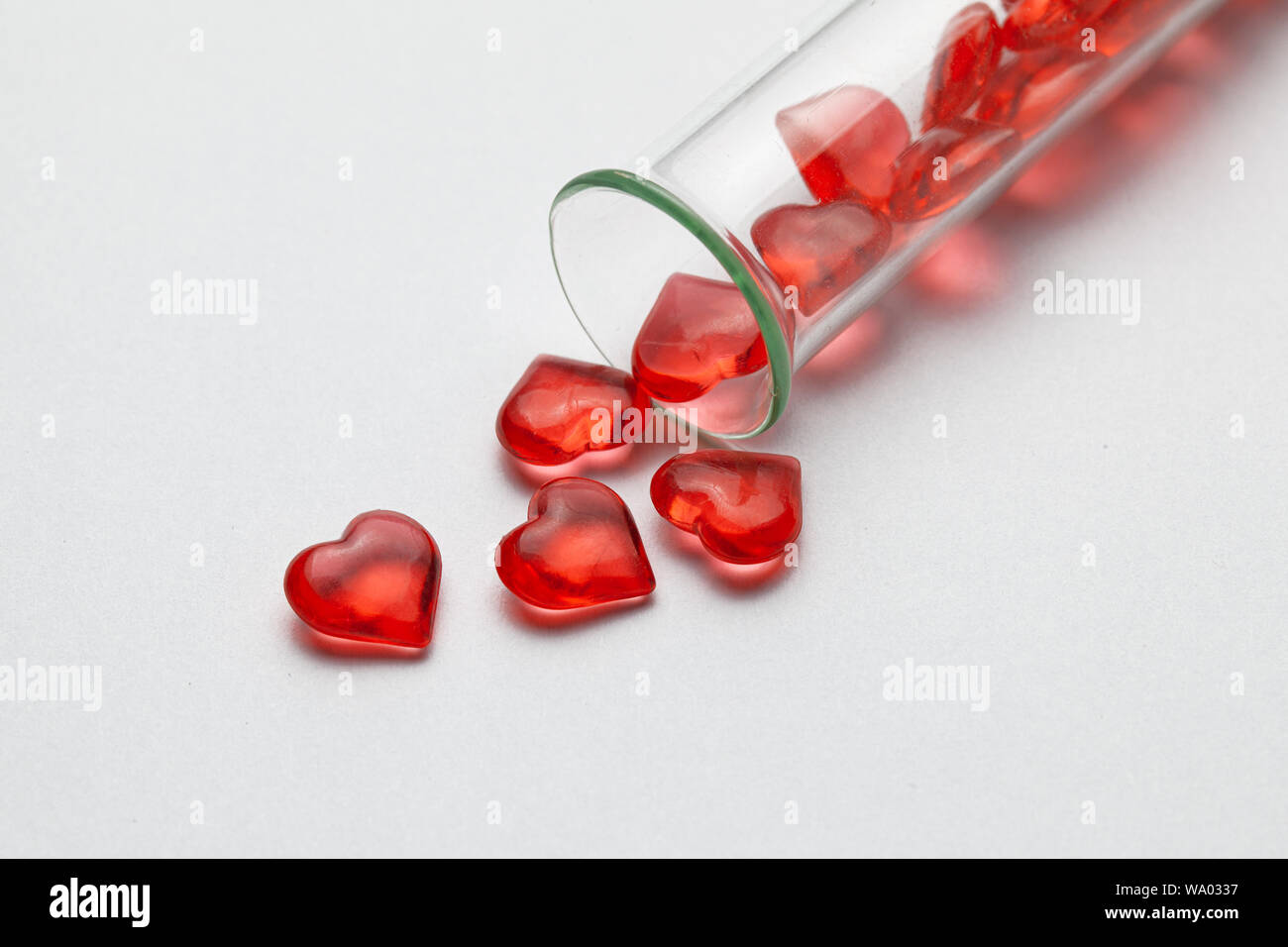 Hearts and test tube. Baby from tube vitro glass. Artificial insemination, IVF. Gray background Stock Photo