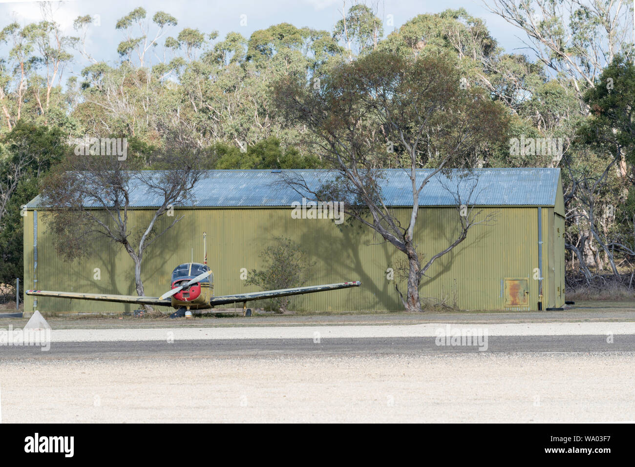 A small hanger and a wrecked single engine plane at the historic Mittagong Aerodrome airfield in the Southern Highlands of New South Wales, Australia Stock Photo