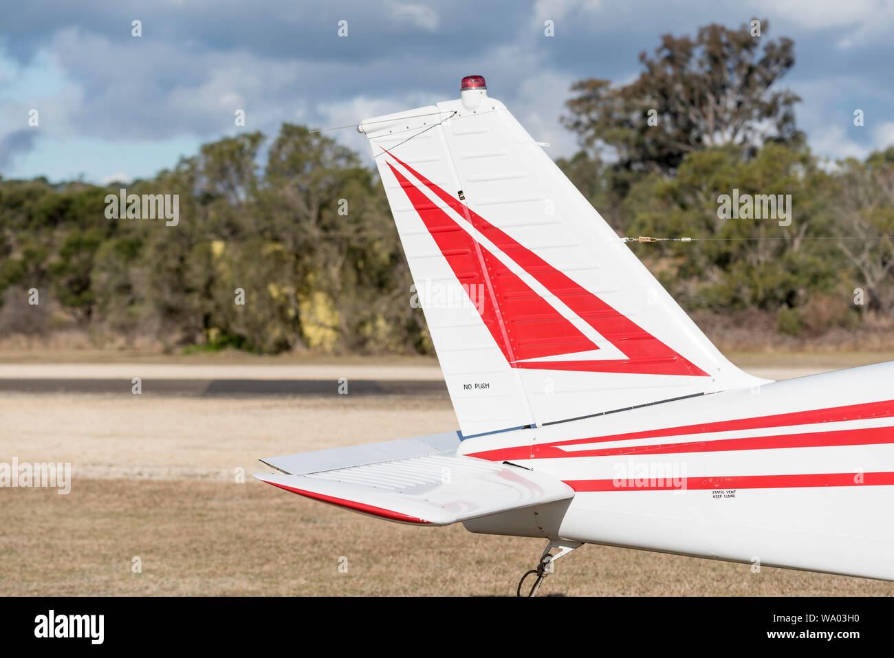 A partial view of a single light plane sitting parked beside the runway at the small regional airstrip at Mittagong Aerodrome in New South Wales Stock Photo