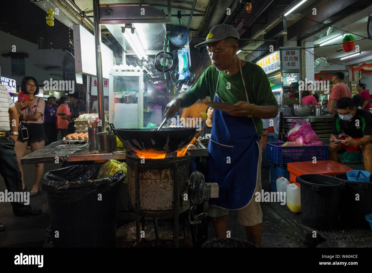 At a typical night hawker stall food market, a vendor makes the classic