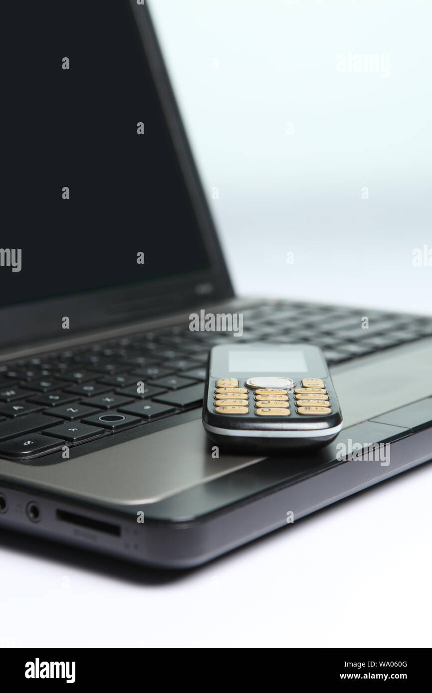 Laptop with mobile phone Stock Photo - Alamy