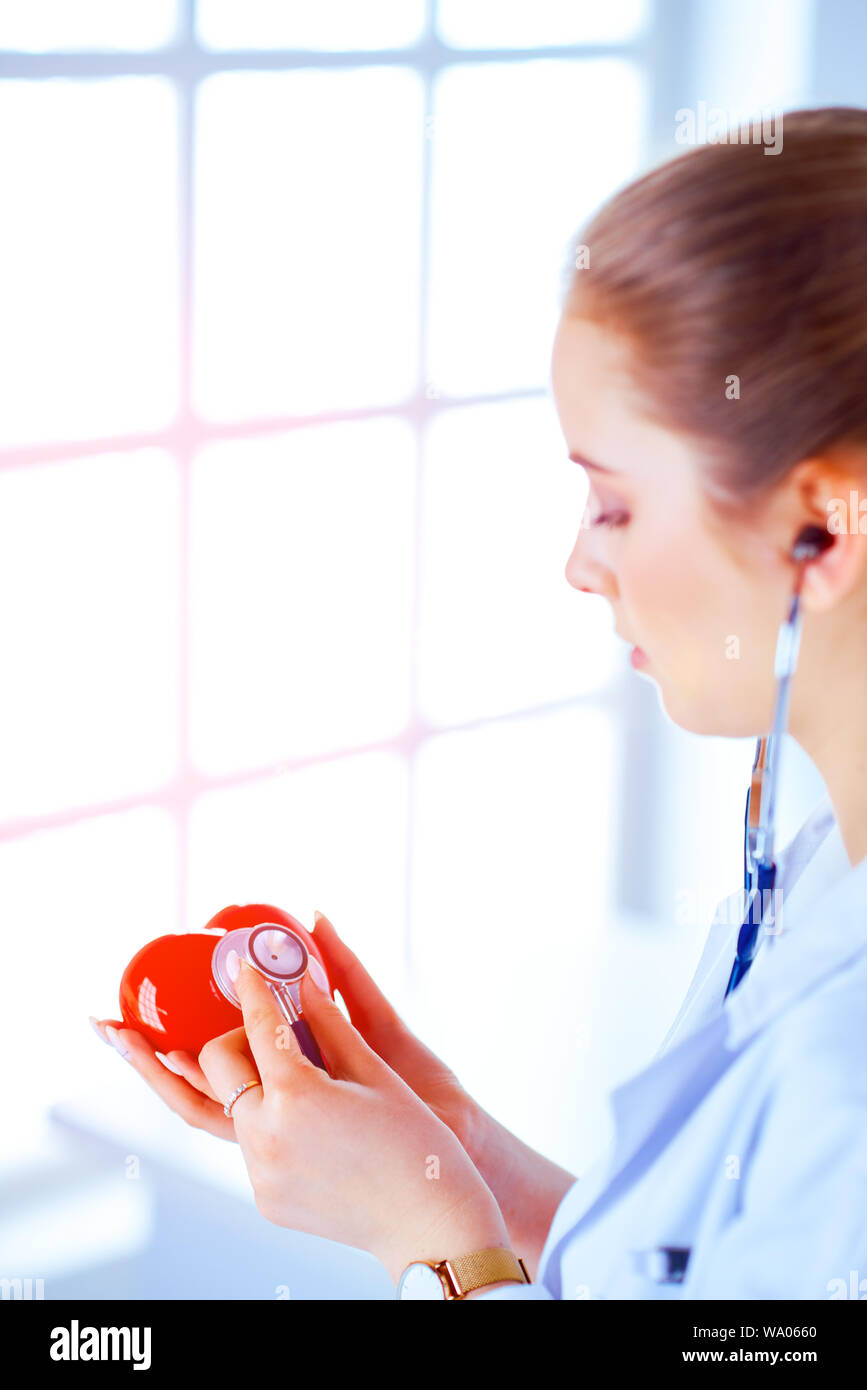 Doctor cardiologist examines the heart with a stethoscope. Young female ...
