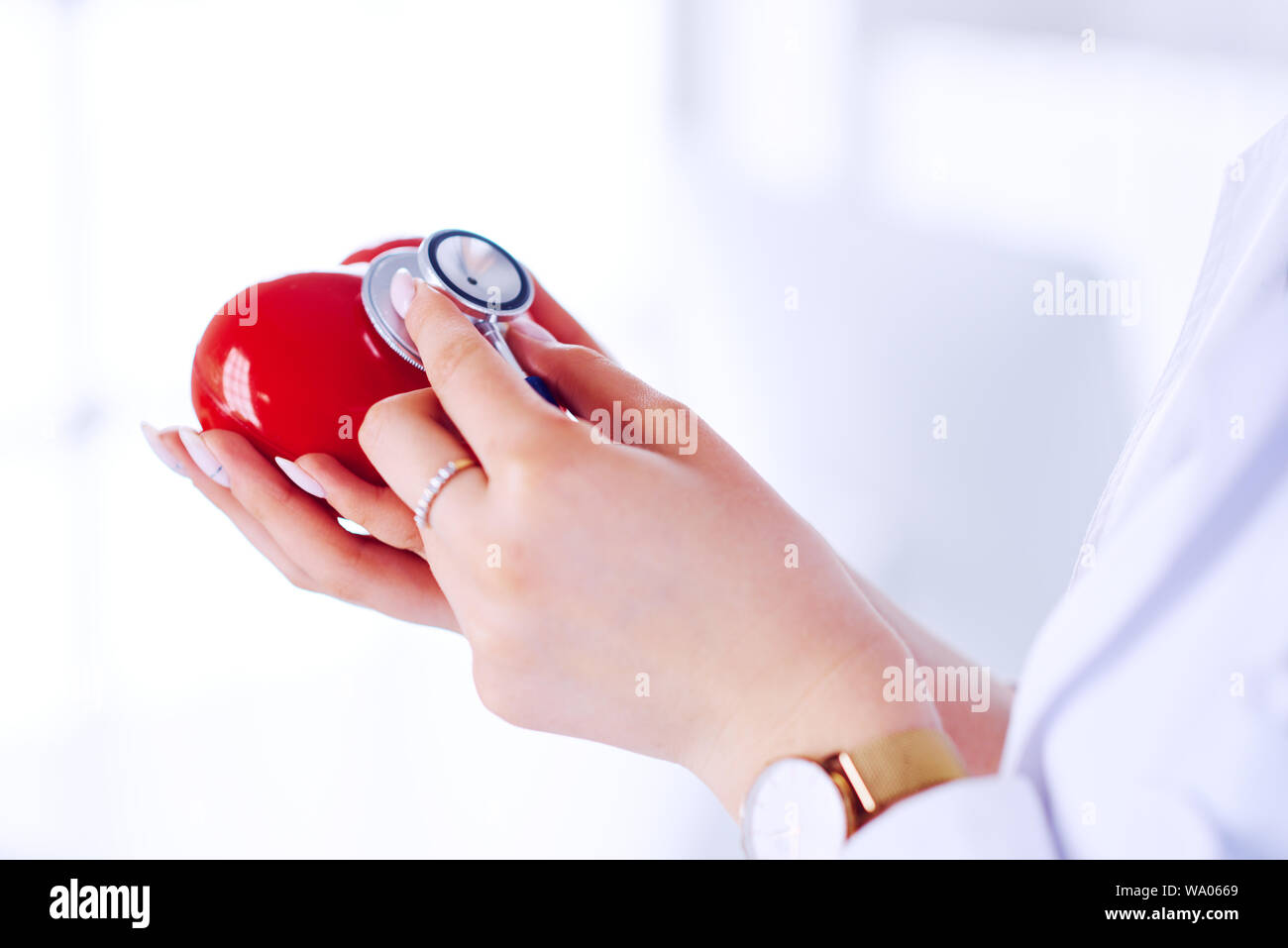 Doctor in a hospital examines a heart with a stethoscope. Workplace ...