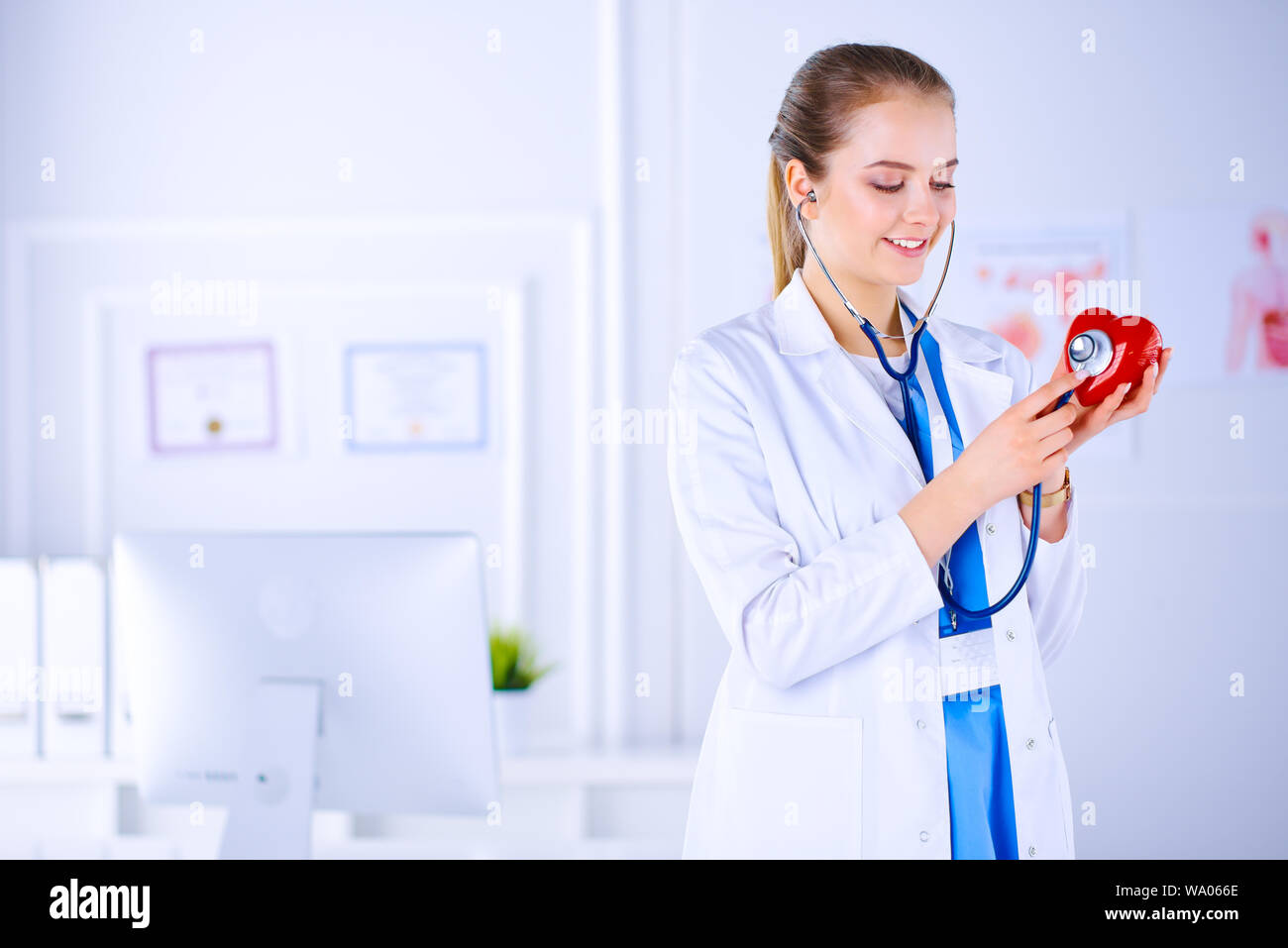 Doctor cardiologist examines the heart with a stethoscope. Young female ...