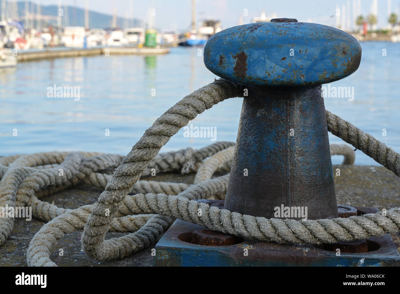 bollard from iron with a ship rope at the pier on the port