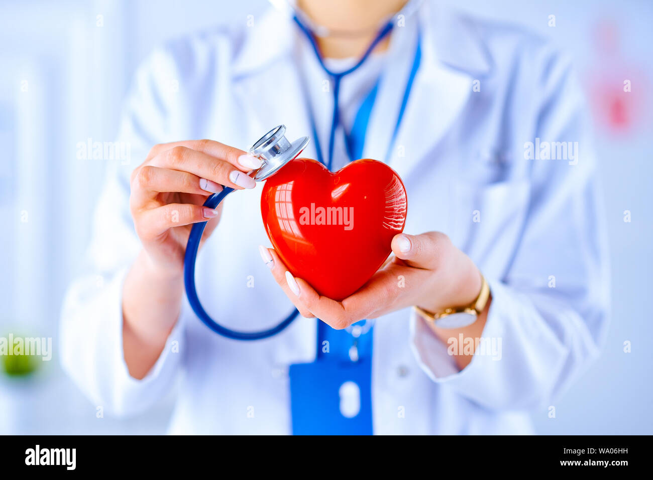 Female doctor with stethoscope examining red heart. Health, medicine ...