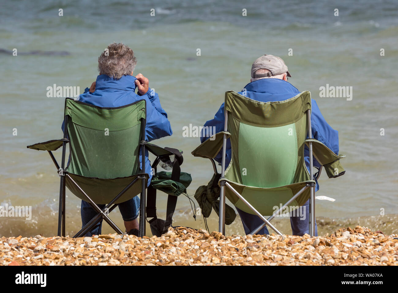 Couple sitting in deckchairs on the beach hi-res stock photography and ...