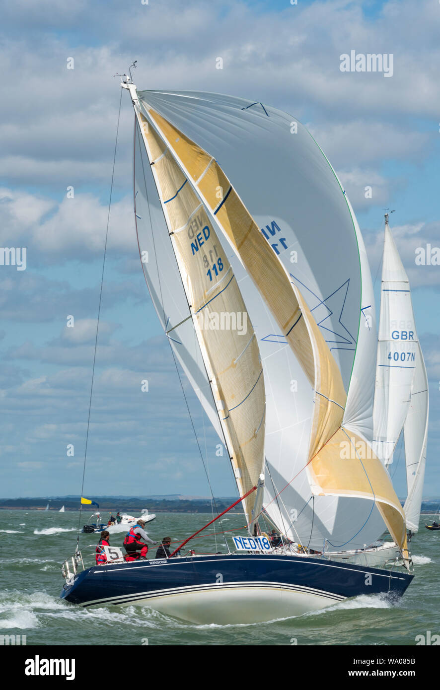 A large racing yacht under full sail and spinnaker on the sea in rough ...