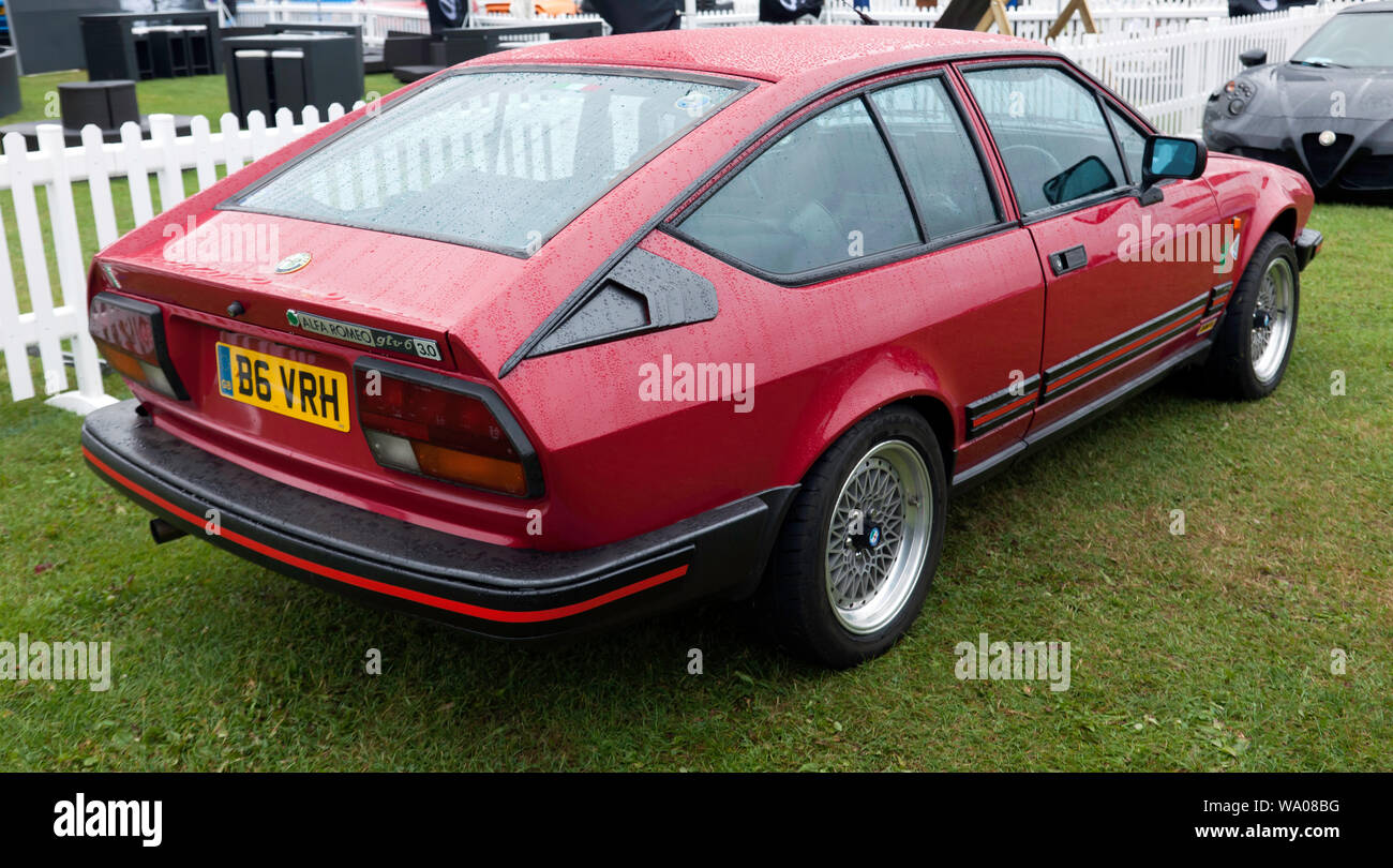 Three-quarter rear view of a Red 1984,  Alfa Romeo GTV 6  on display in the Alfa Romeo Owners Club Zone, at the 2019 Silverstone Classic Stock Photo