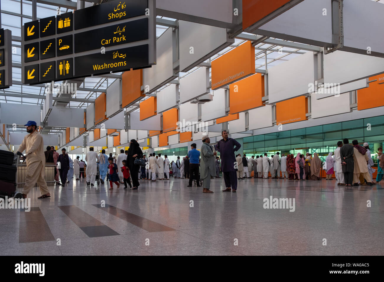 Travelers under colorful ceiling of  Islamabad International Airport, Pakistan. Stock Photo