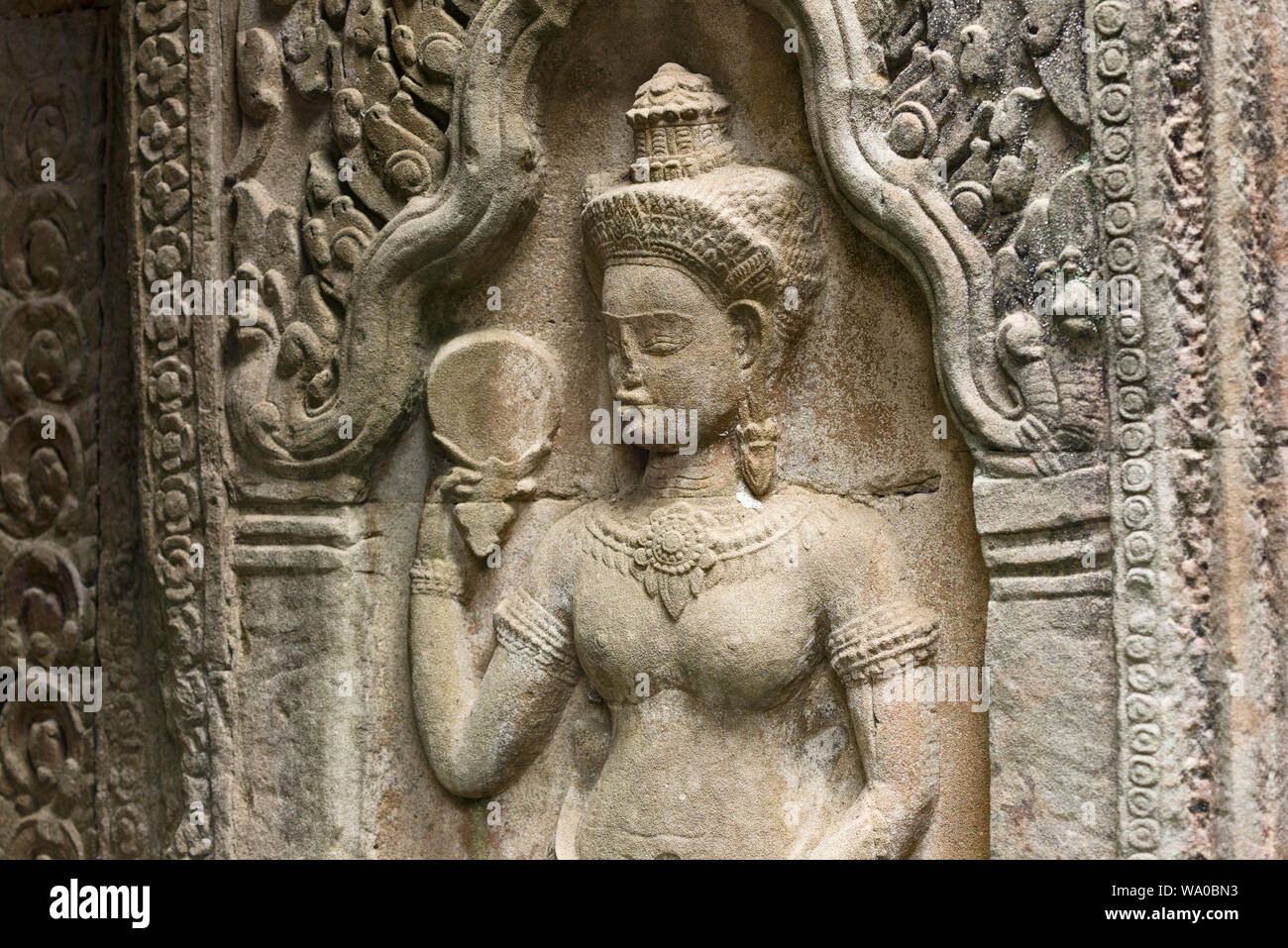 Devata are feminine deities or celestial nymphs with an enigmatic smile in Preah Khan temple, Khmer ruins in Angkor Thom in Siem Reap Cambodia Stock Photo