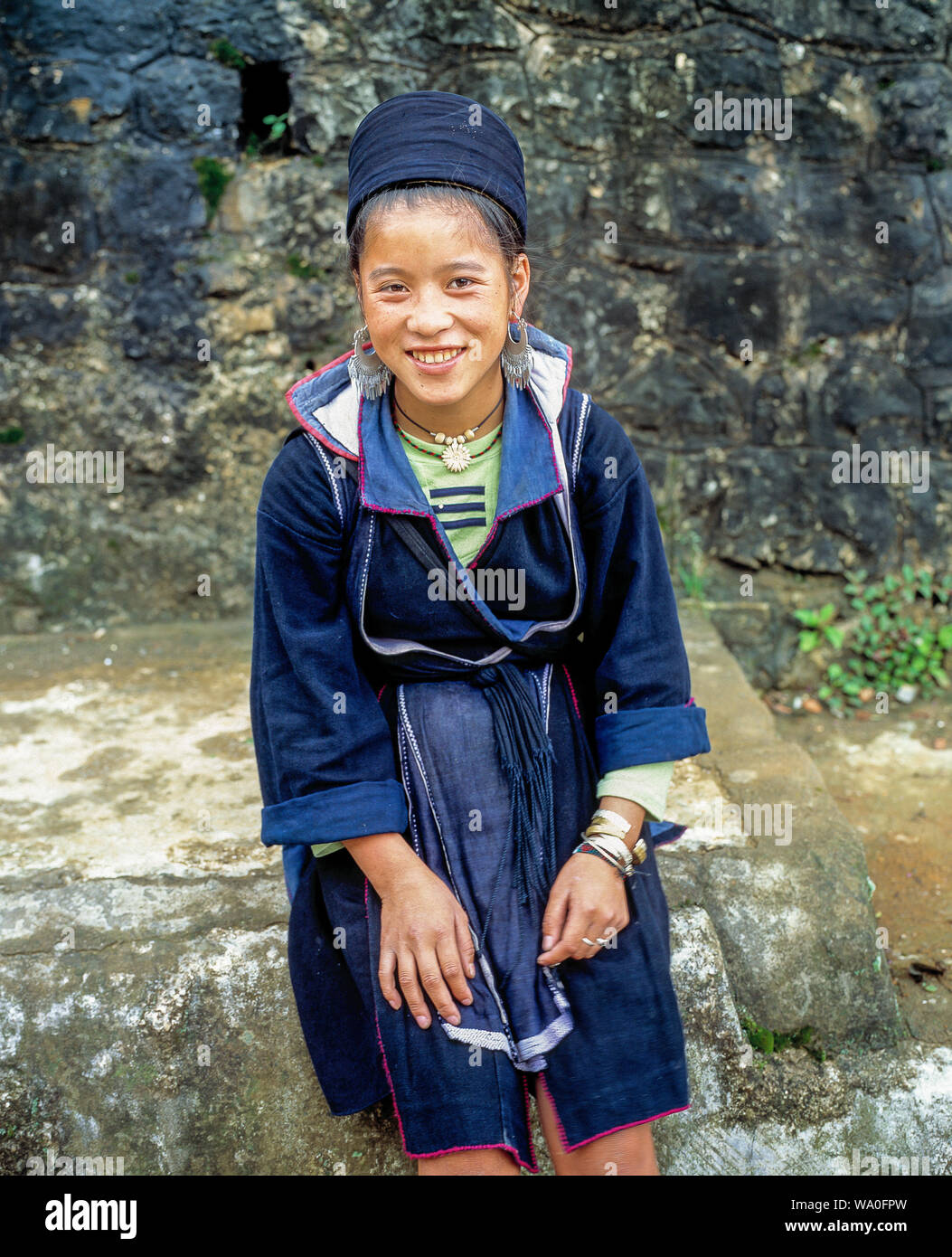 Portrait of happy young Black Hmong woman in traditional dress in Sapa